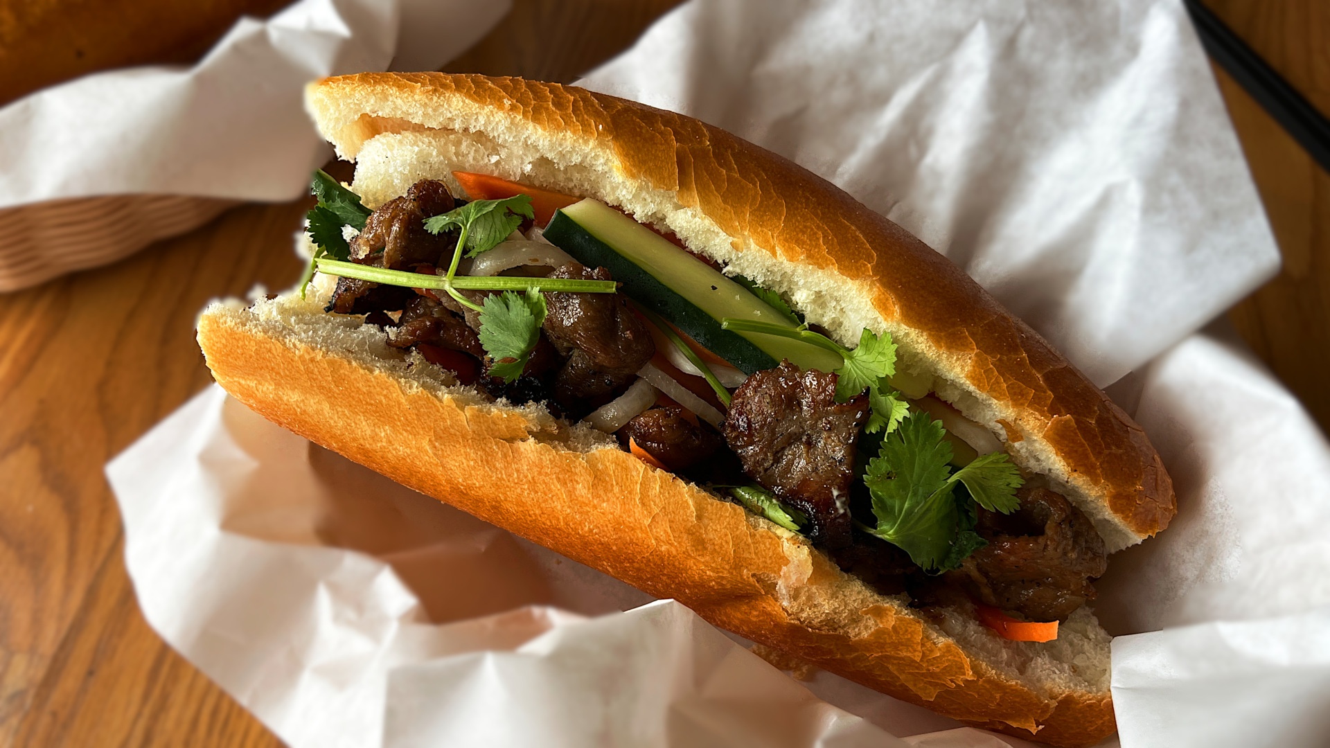 Vietnamese bánh mì with grilled pork, pickled vegetables, cucumber, and cilantro on a crispy baguette